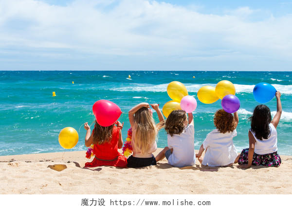 年幼的孩子坐在海滩上玩气球六一儿童节61儿童节